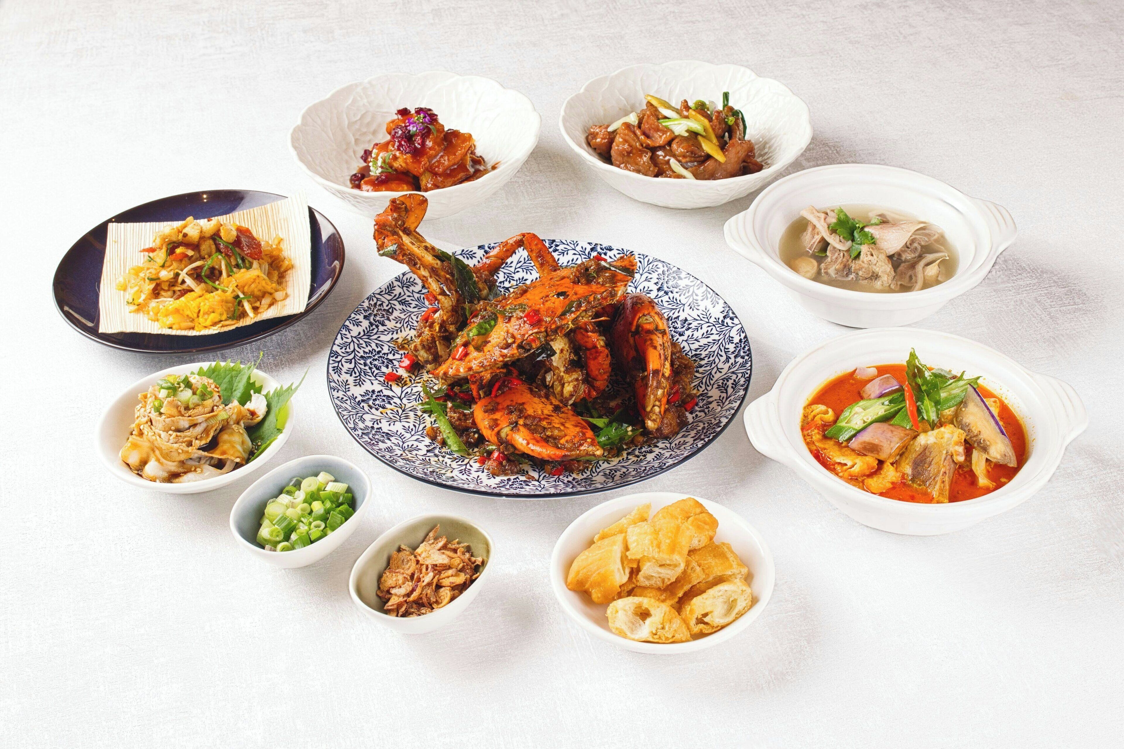 A variety of dishes including a whole roasted chicken, several bowls of soup, and a plate of fried items.