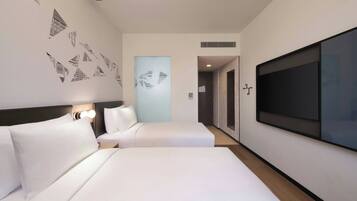 Habitación de hotel con dos camas, un televisor de pantalla plana grande y una pared decorada con arte geométrico.