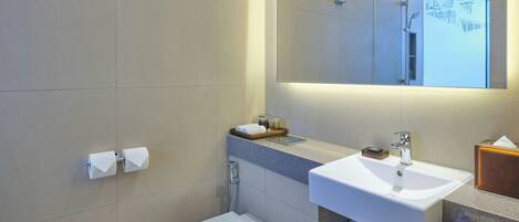 Un baño moderno con inodoro, lavamanos y espejo.