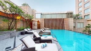 A pool area with lounge chairs and a clear blue pool. - Radisson Blu Hotel Nagpur (Nagpur)