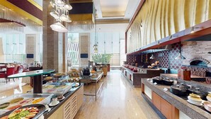 A spacious hotel kitchen with a buffet setup, a pizza oven, and a view of the outdoors. - Radisson Blu Hotel Nagpur (Nagpur)