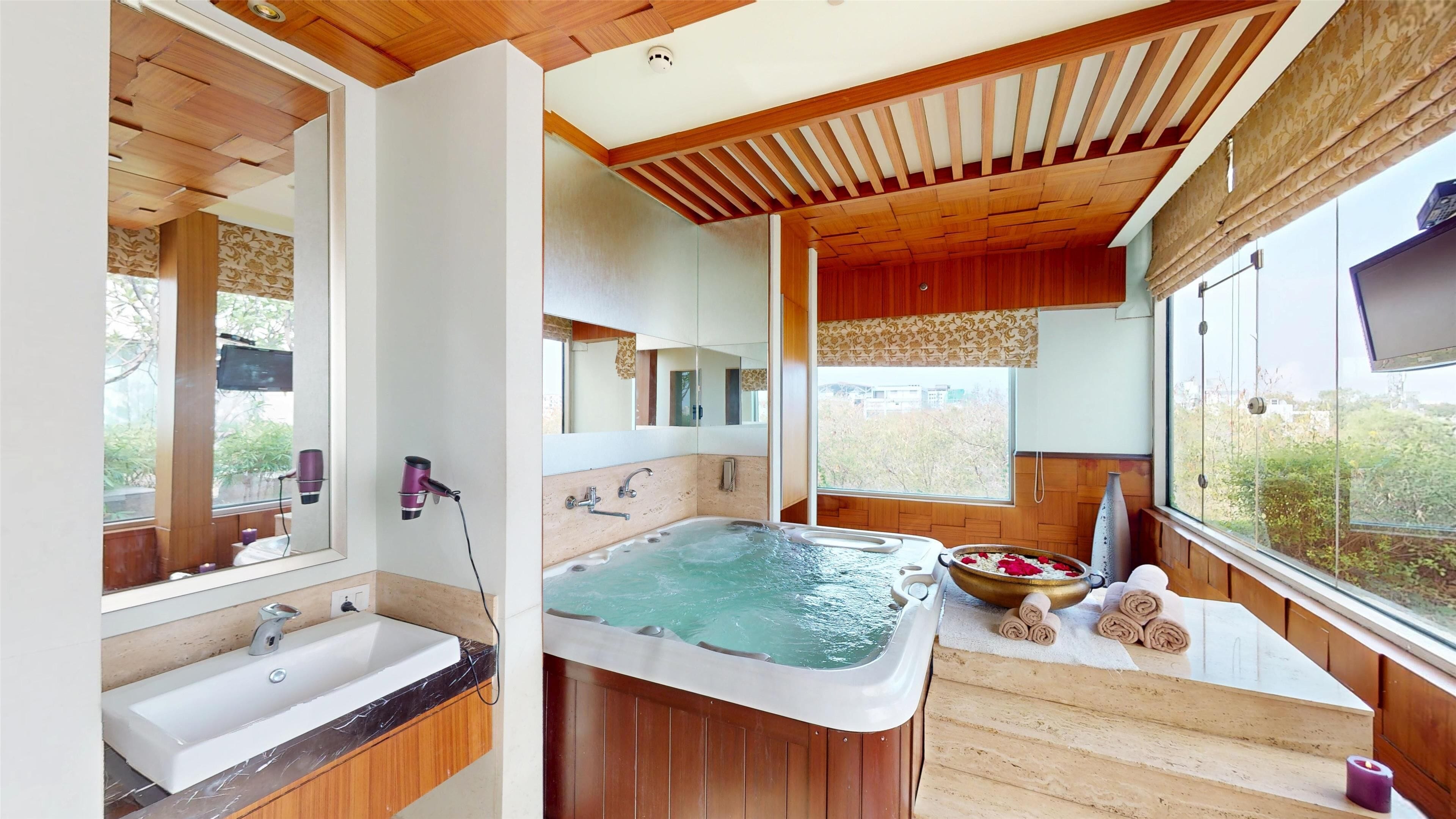 Un baño moderno con una bañera grande, un lavabo y un espejo.