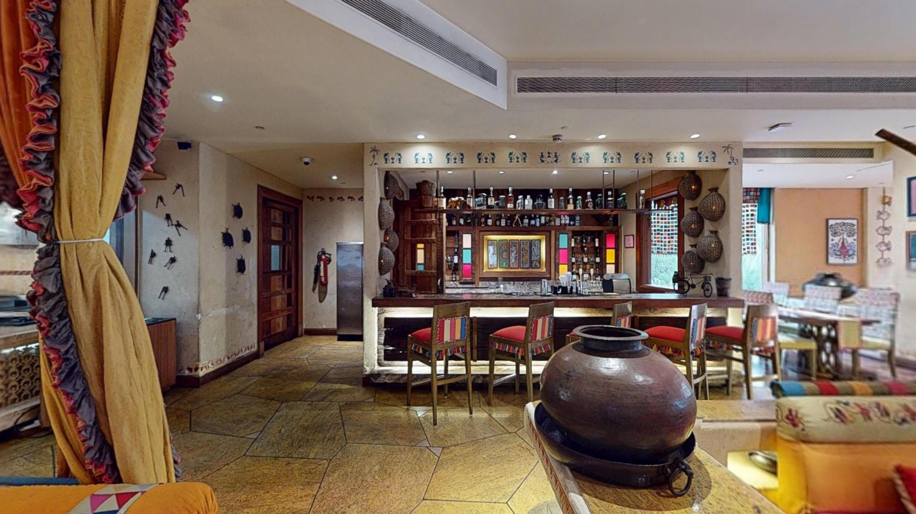Eine Bar mit gefliestem Boden, einer Holztresore und roten Sitzhocker.