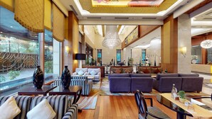 A spacious lobby with a high ceiling, large windows, and a central chandelier. - Radisson Blu Hotel Nagpur (Nagpur)