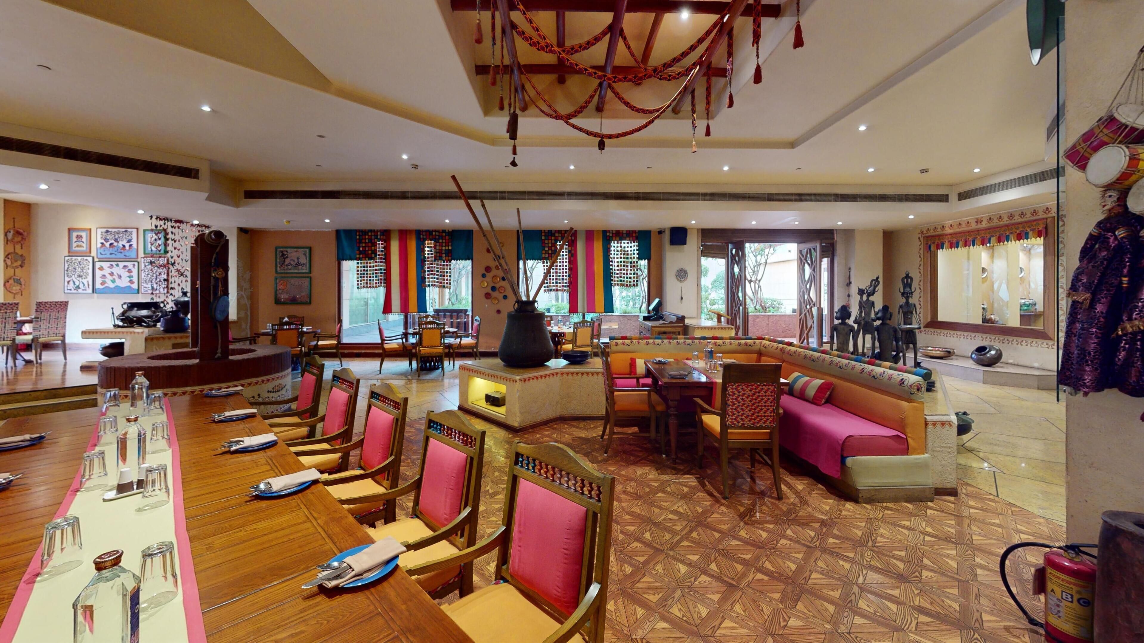 A spacious restaurant with wooden flooring, multiple dining areas, and traditional decor.