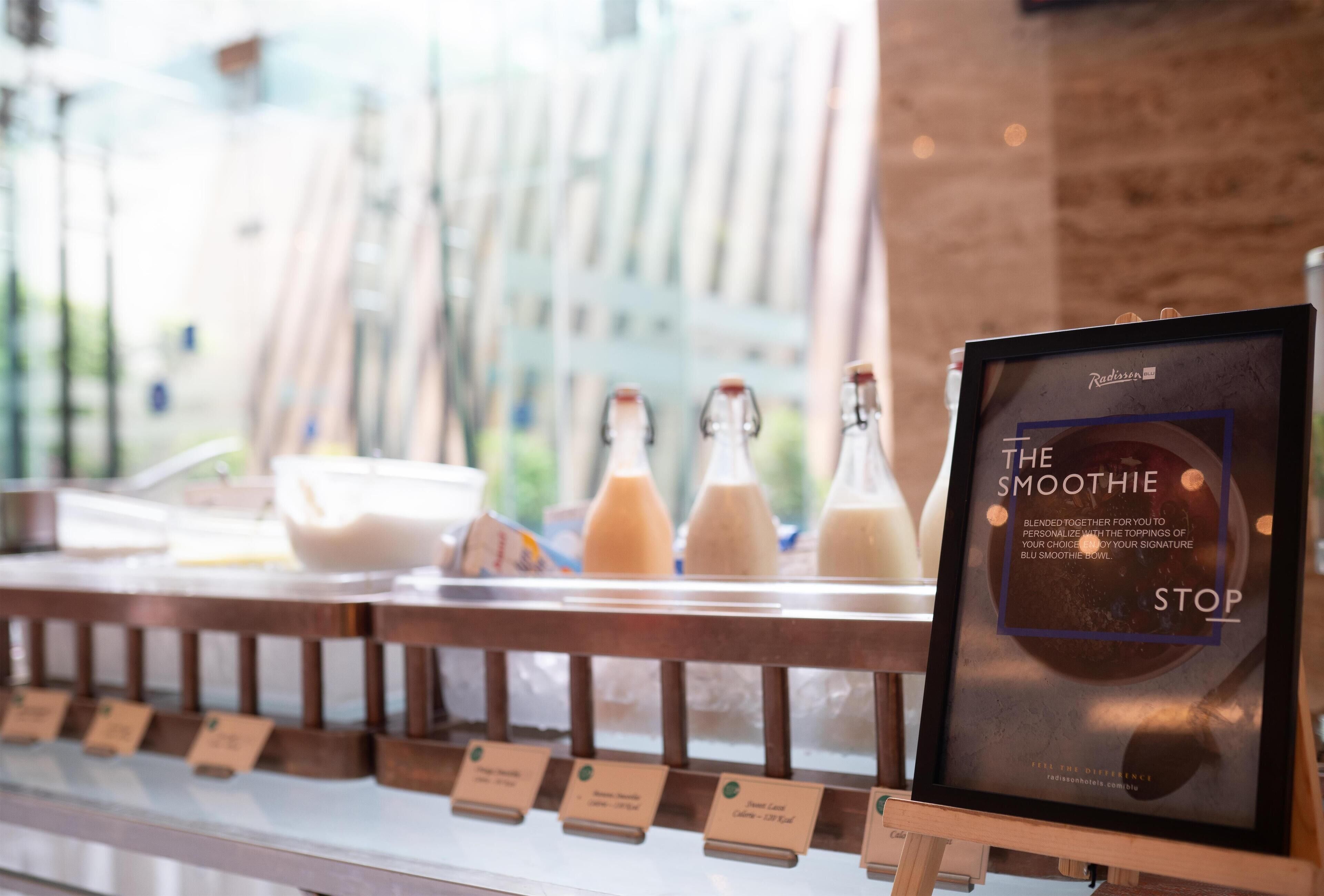 Un mostrador con un panel de menú para batidos, con la etiqueta 'The Smoothie STOP'.
