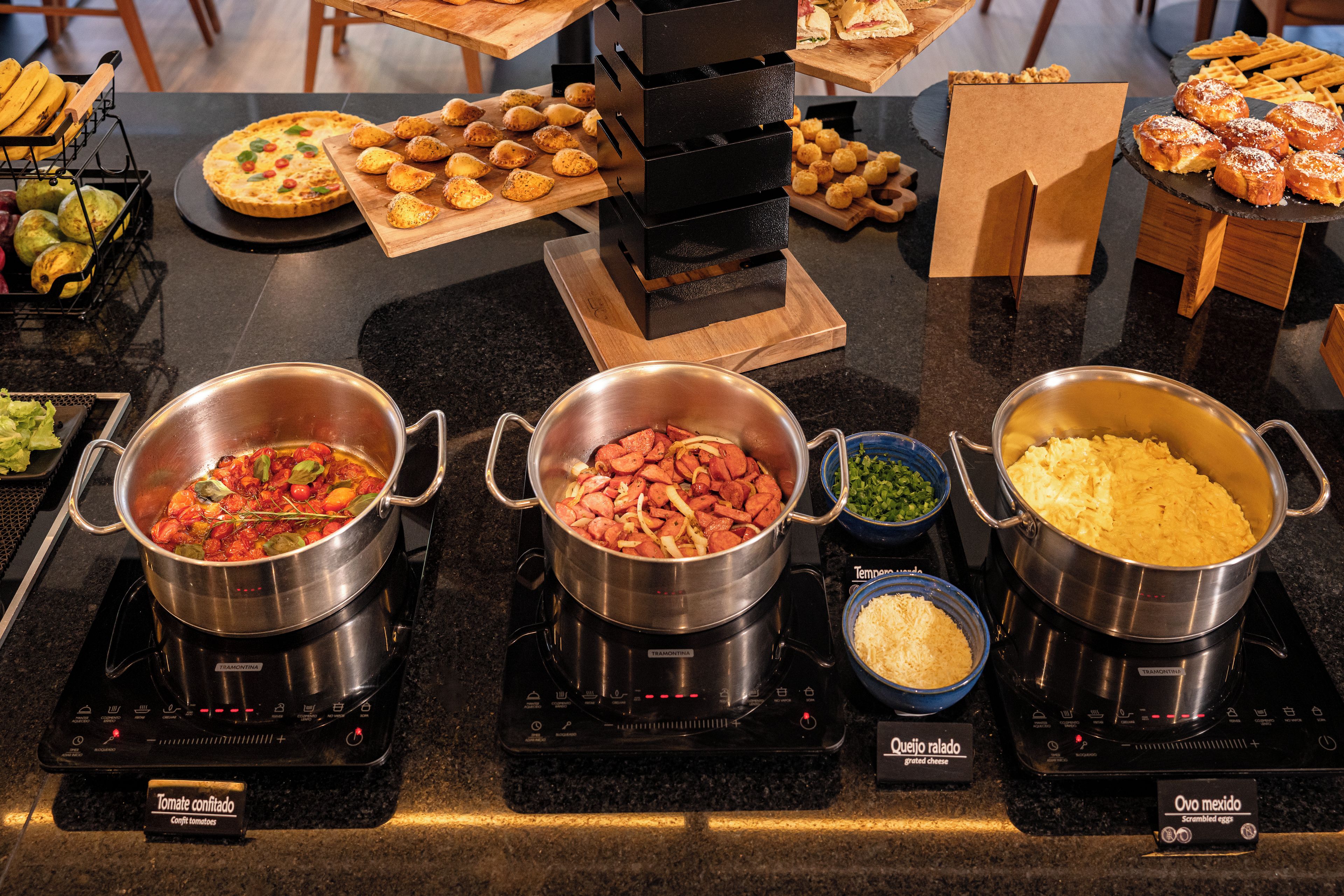 A buffet with various dishes including a pizza, potato wedges, and a variety of other foods.