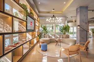 Um interior moderno com um sofá curvo, estantes de madeira e uma janela grande.