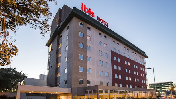 A multi-story hotel with a prominent "ibis Hotel" sign on the roof. - Ibis Canoas Shopping (Canoas)