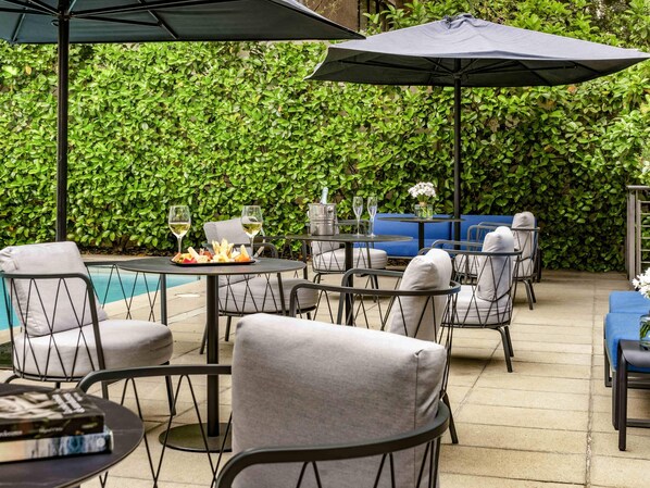 Una piscina al aire libre, camas de piscina gratis, sombrillas