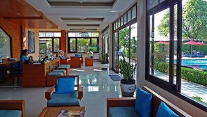 A spacious lobby with a pool view, wooden furniture, and a receptionist desk. - Samui Boat Lagoon (Koh Samui)