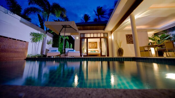 A modern pool area with a clear view of the pool, lounge chairs, and a well-lit interior space. - Samui Boat Lagoon (Koh Samui)