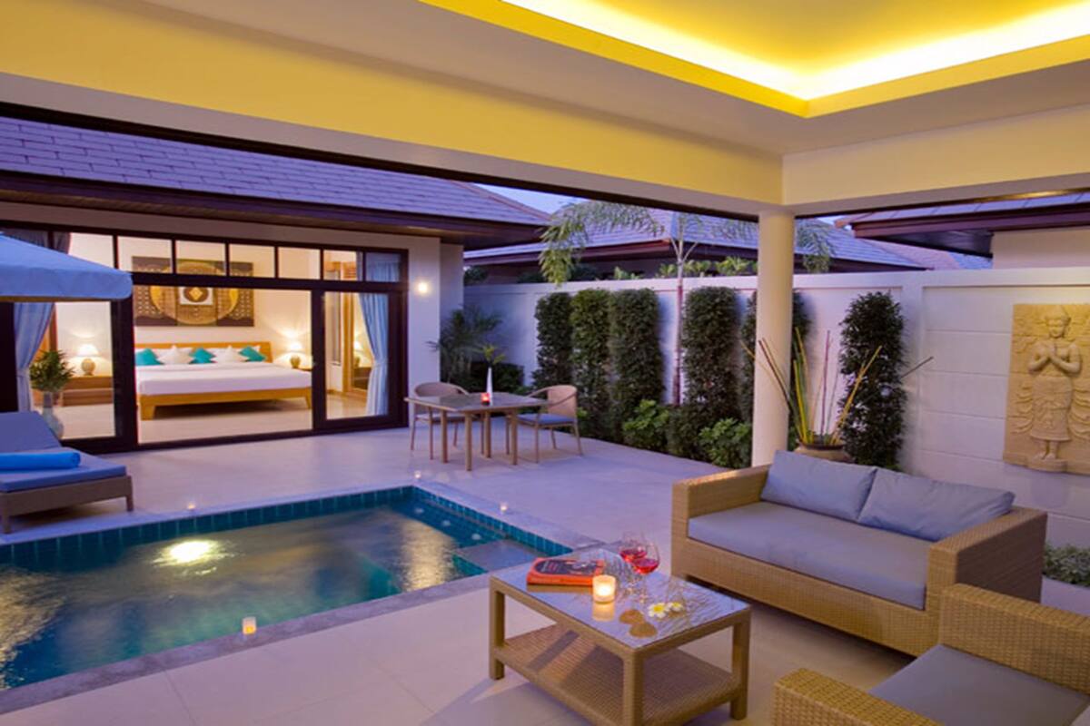 A modern outdoor living area with a pool, seating, and a view of the interior.