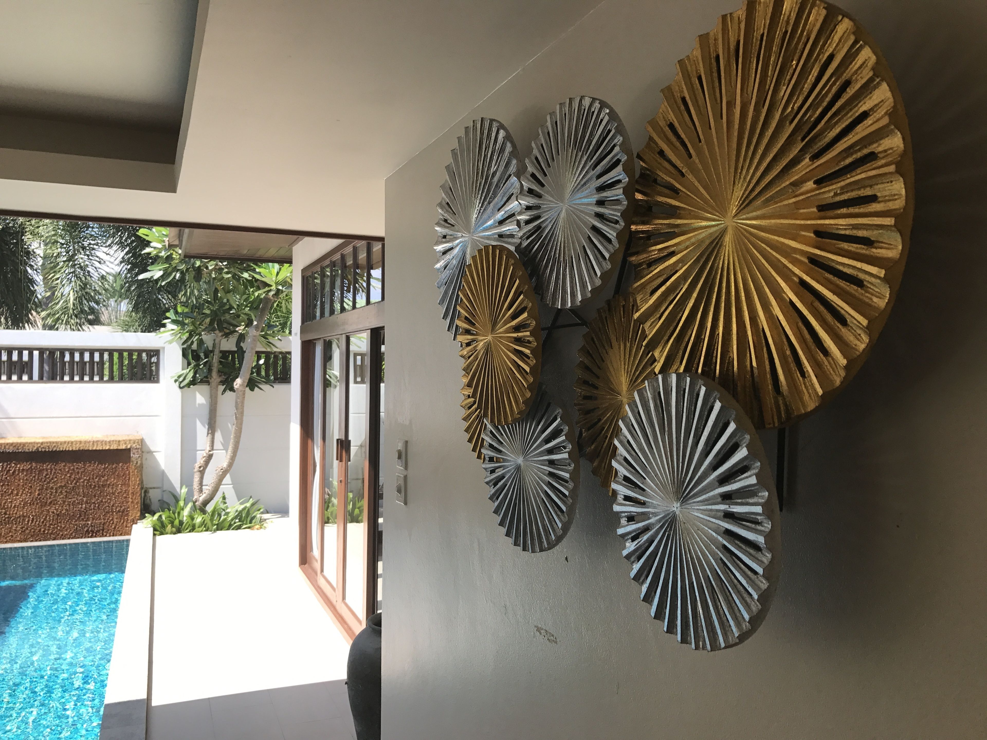 A modern interior with a pool, decorative wall art, and a view of the outside.