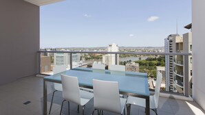 A balcony with a glass table and chairs, offering a view of the cityscape. - Mantra Midtown (Brisbane)