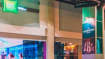 L’entrée d’un hôtel, avec une enseigne verte indiquant « ibis Styles Hotels » et une grande affiche pour « AccorHotels ».