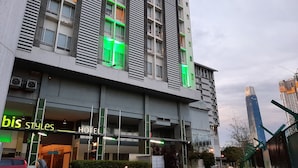 Un hotel moderno con un llamativo letrero que dice 'bis Styles Hotel', grandes ventanales y una entrada con portón.