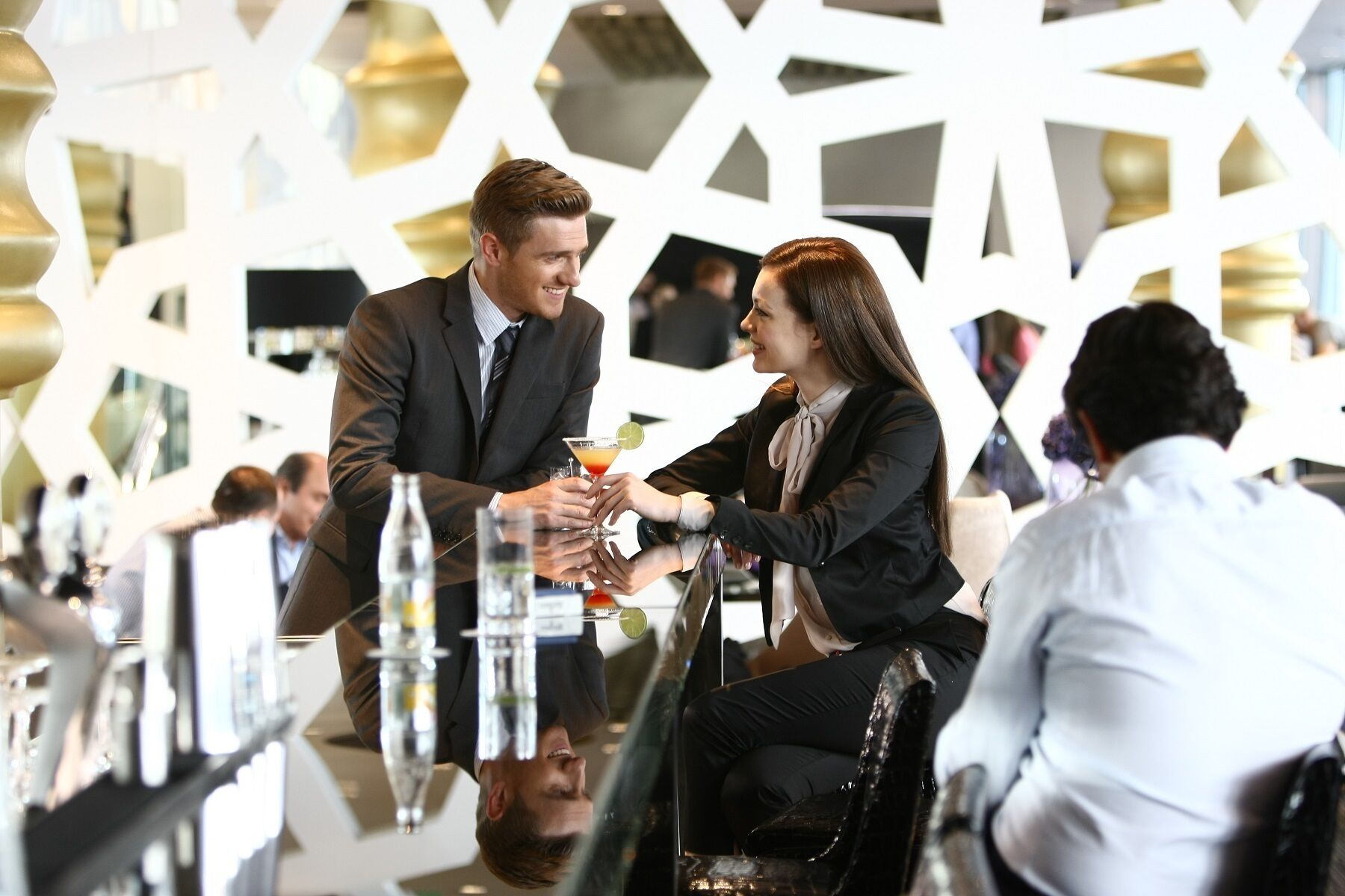 A modern indoor setting with geometric wall designs and a bar area.