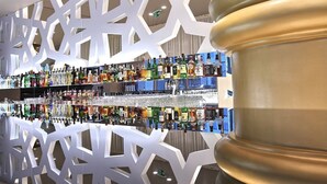 Eine Bar mit einer Spiegelwand und einer Auswahl an Spirituosenflaschen.
