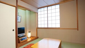 A traditional Japanese room with tatami flooring, a low table, a television, and a window with a grid pattern. - Hotel Awina Osaka (Osaka)