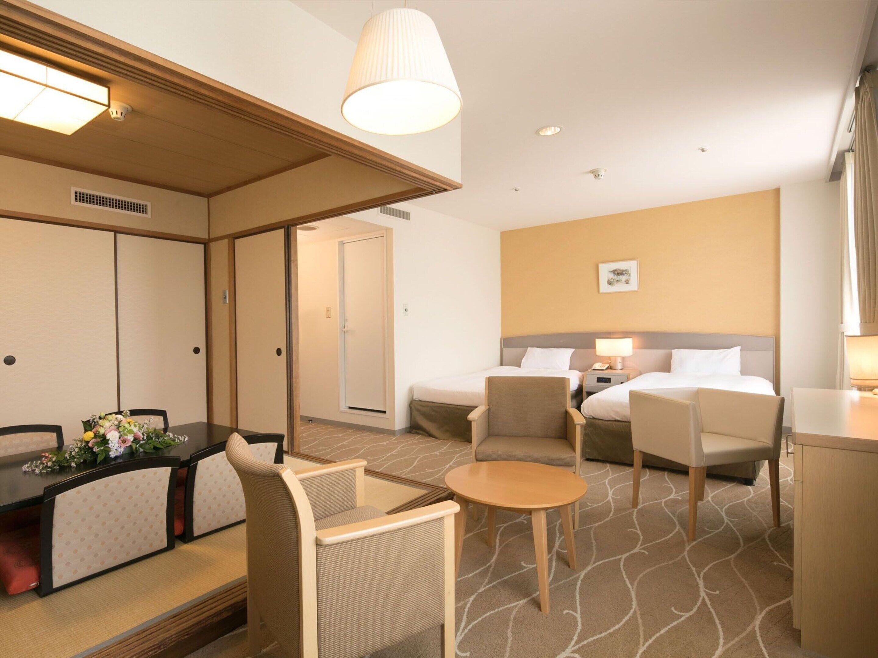 A hotel room with a dining area, two beds, a small table, and a sofa. - Hotel Awina Osaka (Osaka)