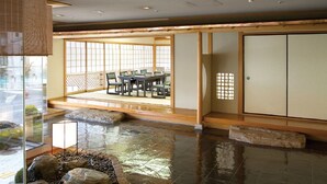 A traditional Japanese room with tatami flooring, a low table with cushions, and a sliding door. - Hotel Awina Osaka (Osaka)