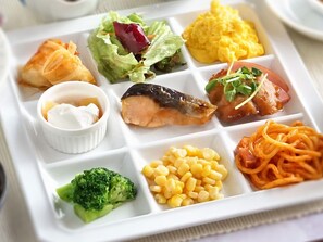 A meal tray with various dishes including fish, salad, scrambled eggs, pasta, and vegetables. - Hotel Awina Osaka (Osaka)