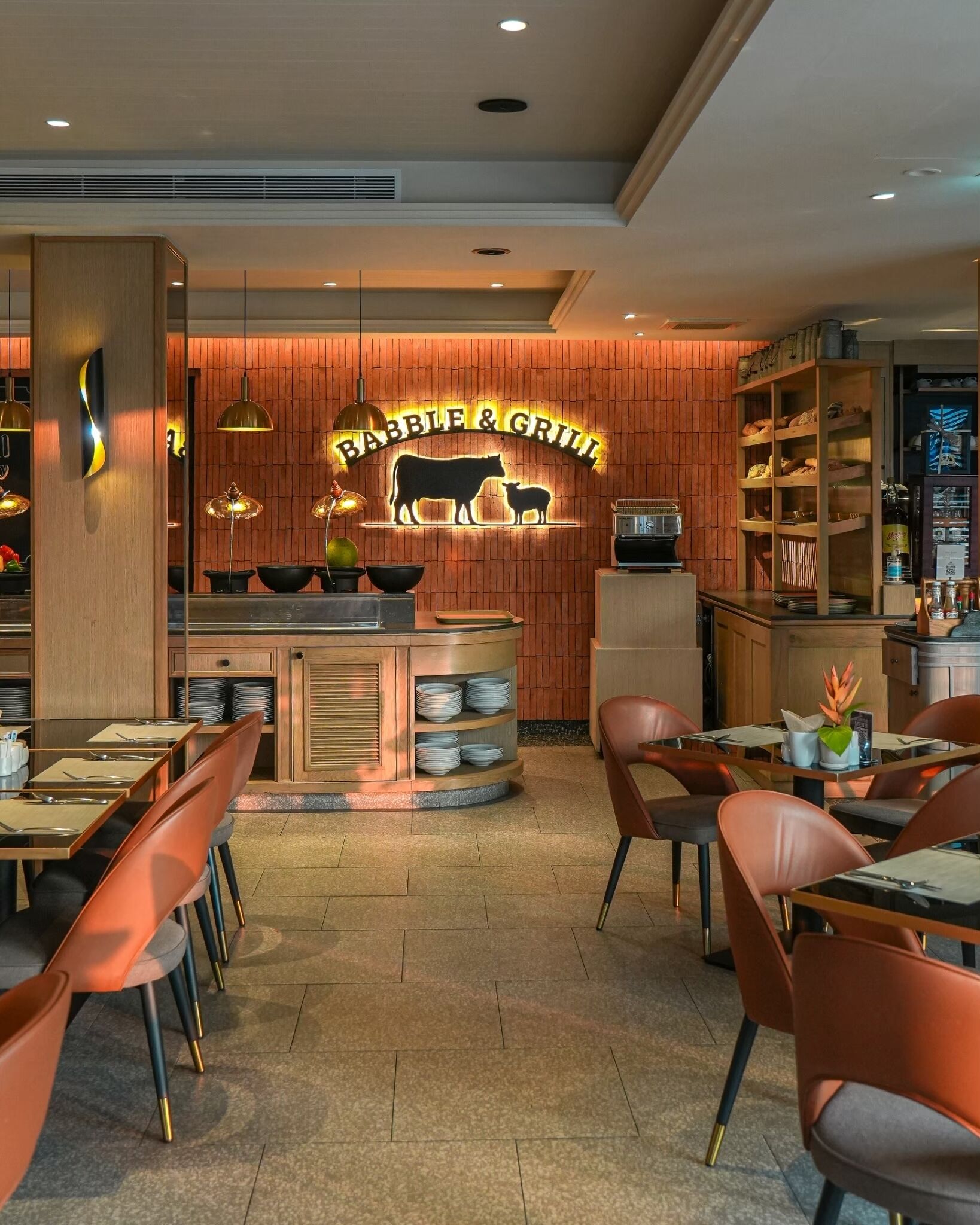 Interior de restaurant amb un taulell central, parets de fusta i il·luminació moderna.