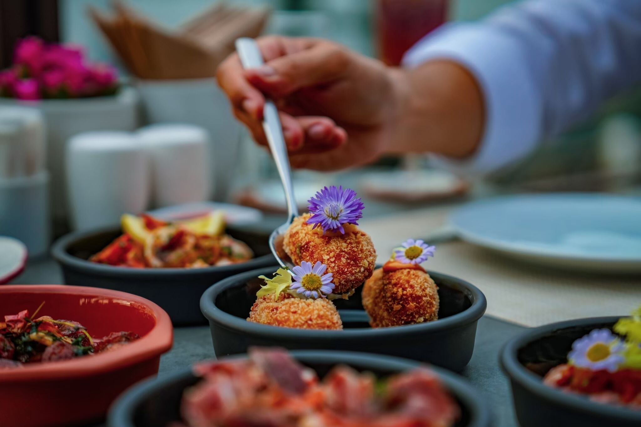 A person serving food from a black bowl.