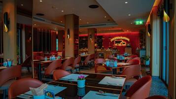A restaurant with red chairs, tables, and a neon sign reading "BARBERRY".