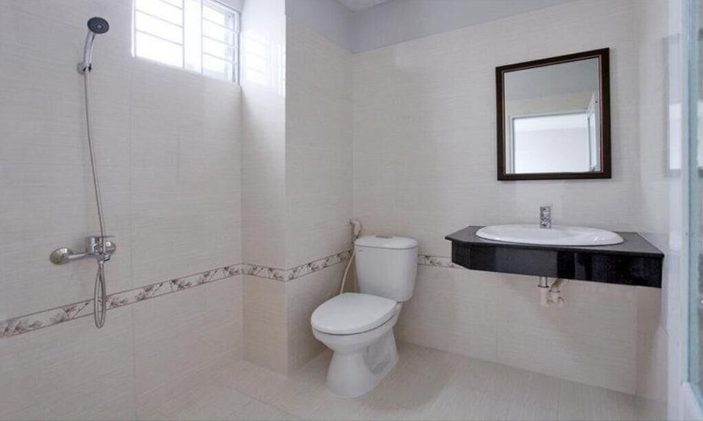 A bathroom with a shower, toilet, and sink.