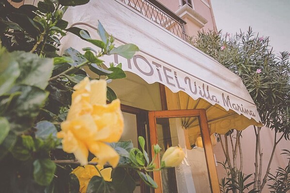 A hotel named "Hotel Villa Marina" with a visible entrance and a balcony.