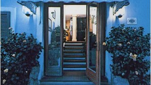 Entrada de un hotel con toldo a rayas y un cartel que dice "HOTEL Villa Marina".