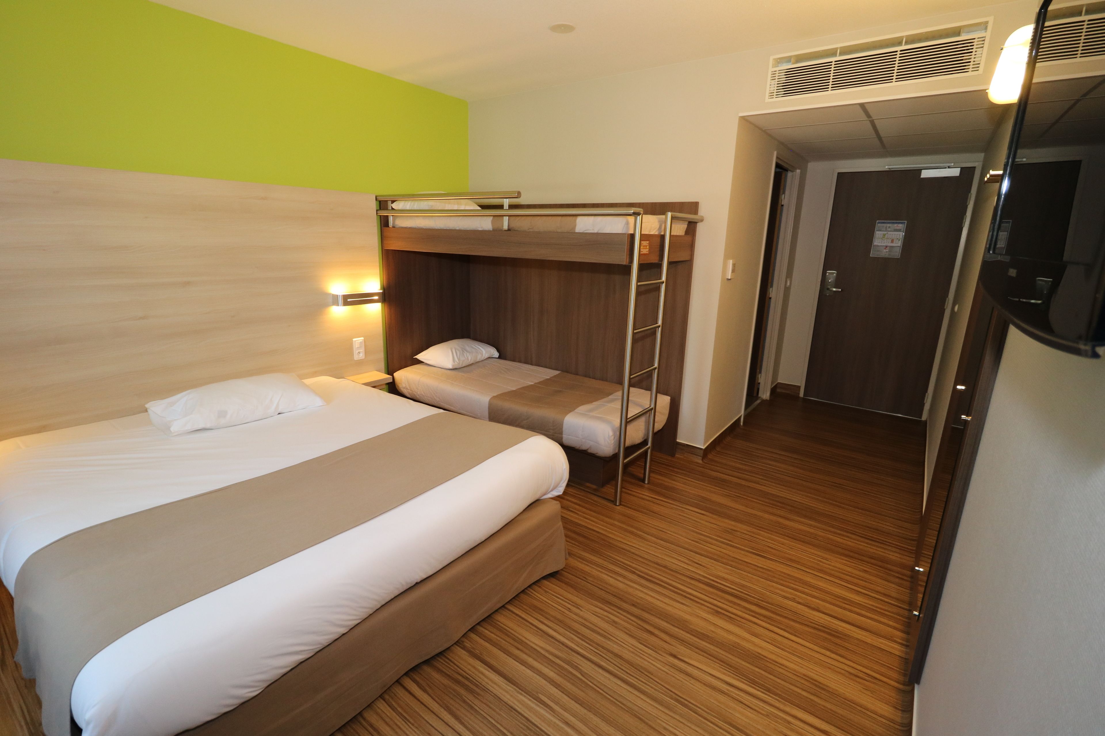 A room with a bunk bed, a desk, and a chair.