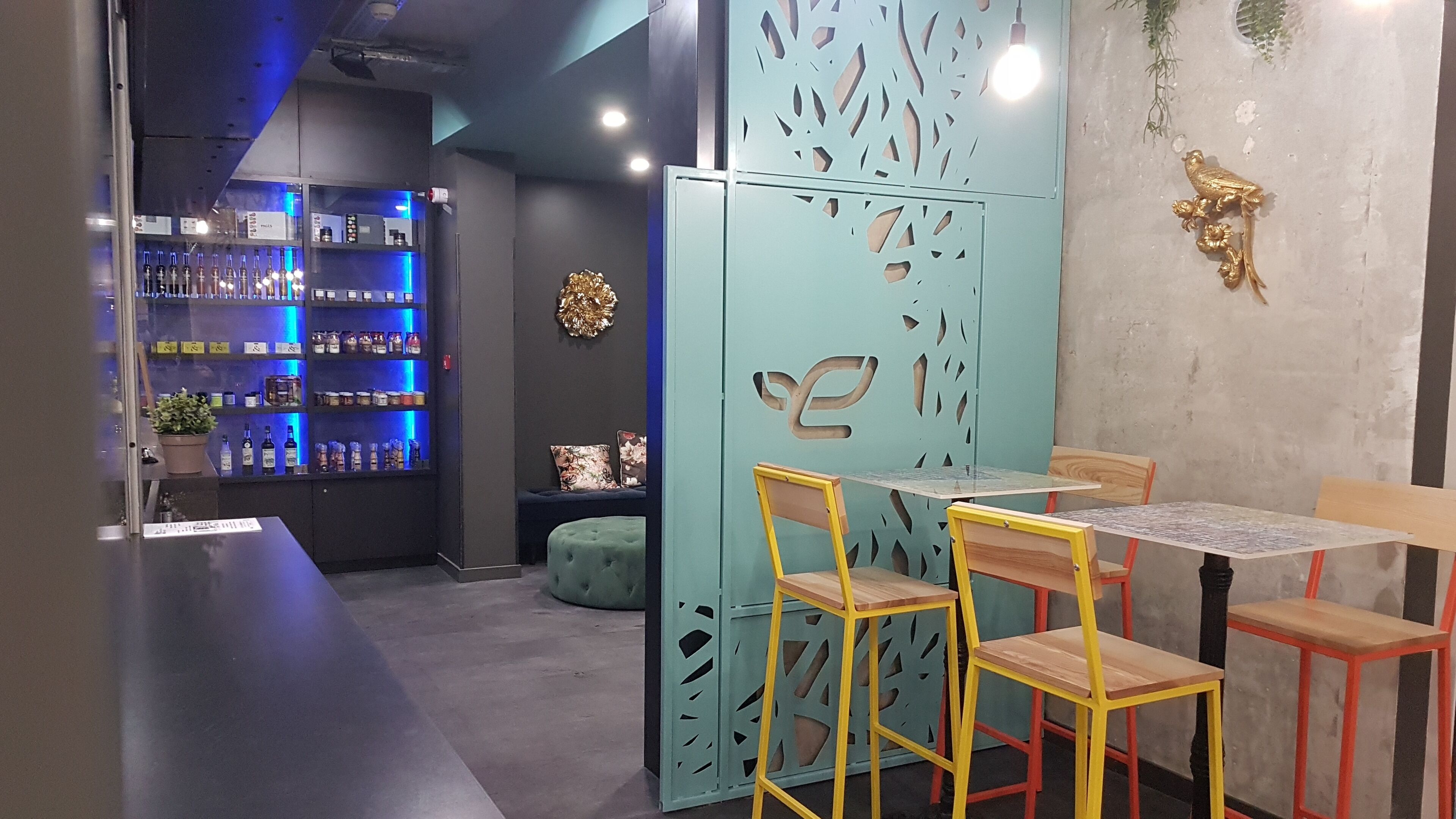 A bar area with shelves of bottles and a seating area with chairs and tables.