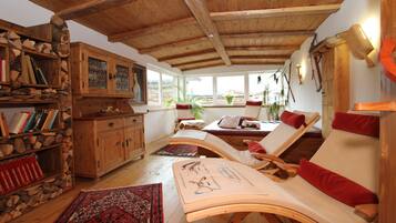 Relax in a warm, inviting space with a lounge area, cabinet, and large window offering a view of the outdoors.