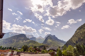 A mountainous landscape with a village, including houses and a building with a sloped roof. - Mühlpointhof (Lofer)