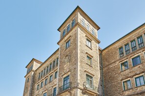 A multi-story building with a stone facade, multiple windows, and a corner tower. - Albergue Seminario Menor - Hostel (Santiago de Compostela)
