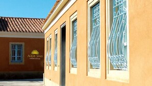 Un edificio con fachada amarilla y un letrero que dice "AQUA SINIS ALBERGO DI FUSO".