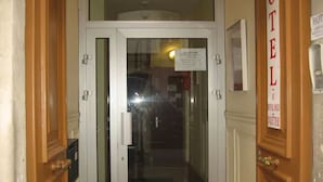A hotel entrance with double doors, a reception desk, and a sign indicating the hotel name. - Au Royal Mad Hotel (Paris)
