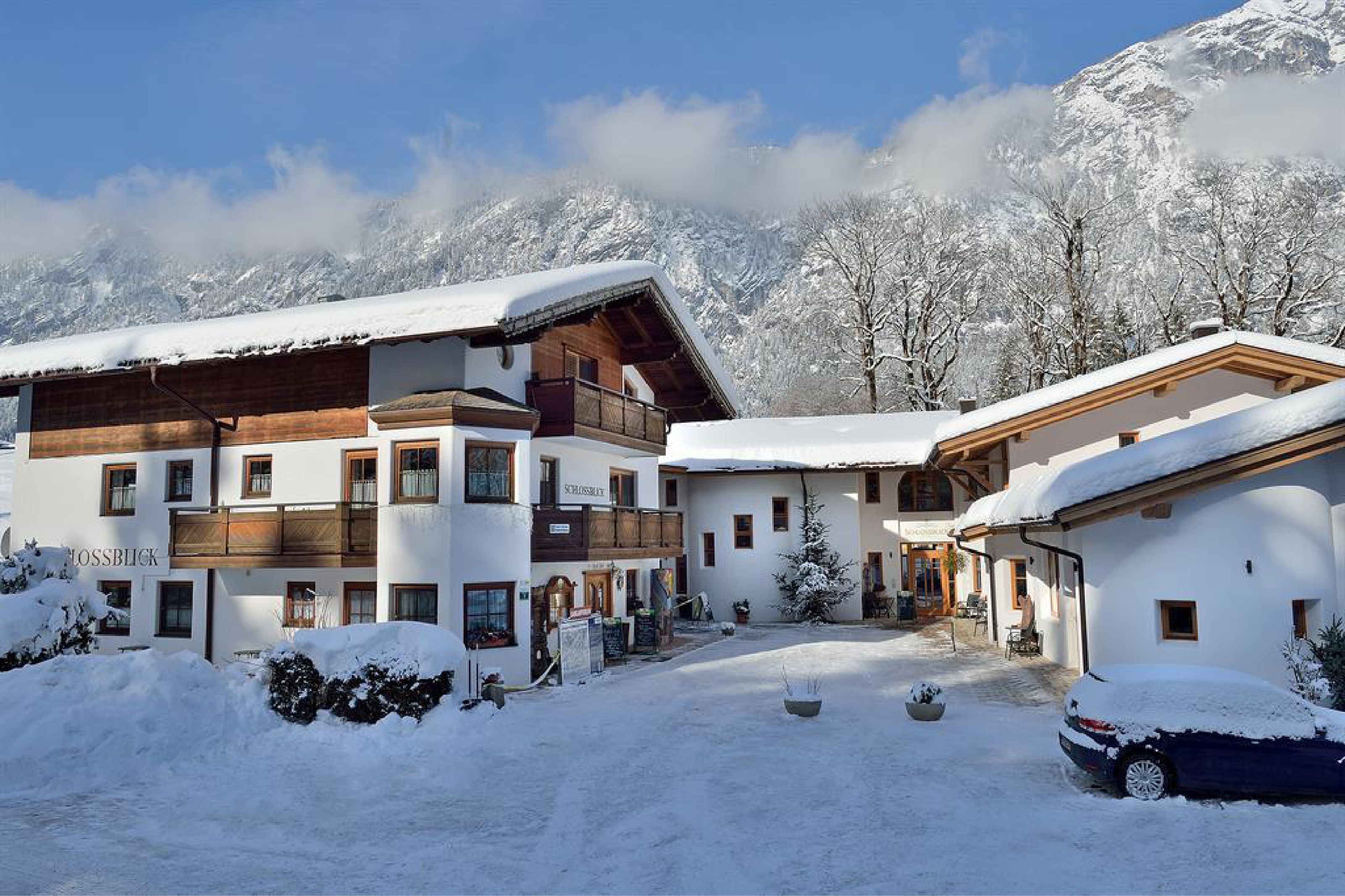 Un edificio cubierto de nieve con fachada de madera, un letrero que dice 