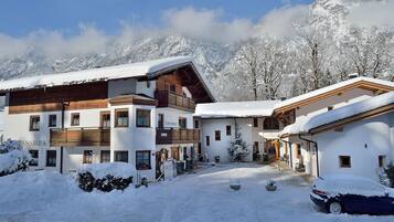 Un edificio cubierto de nieve con fachada de madera, un letrero que dice