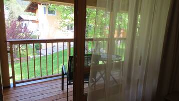A wooden deck with a glass door leading to a patio area.