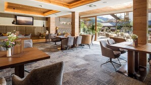 Un restaurante moderno con techos de madera, una televisión grande y vistas al exterior.