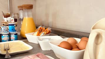 Colazione con uova, prosciutto e succo di frutta.
