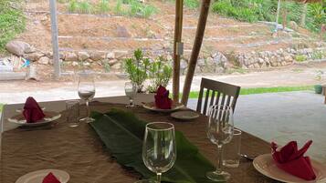 A table set for dining with a thatched roof overhead.