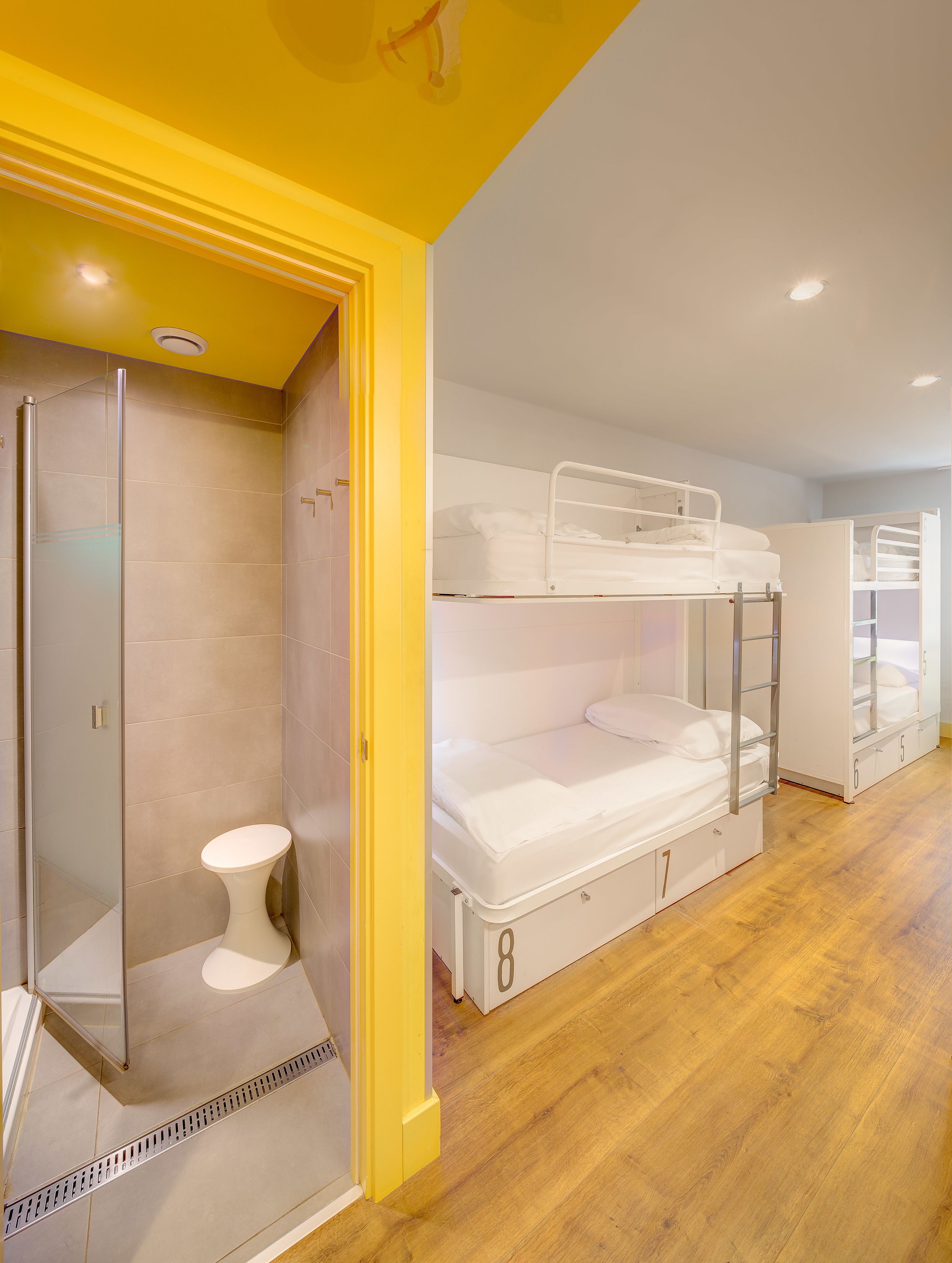 A room with bunk beds, a shower, and a toilet.