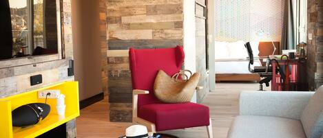 Una sala de estar moderna con un sillón rojo, un sofá gris y un mueble de entretenimiento amarillo.