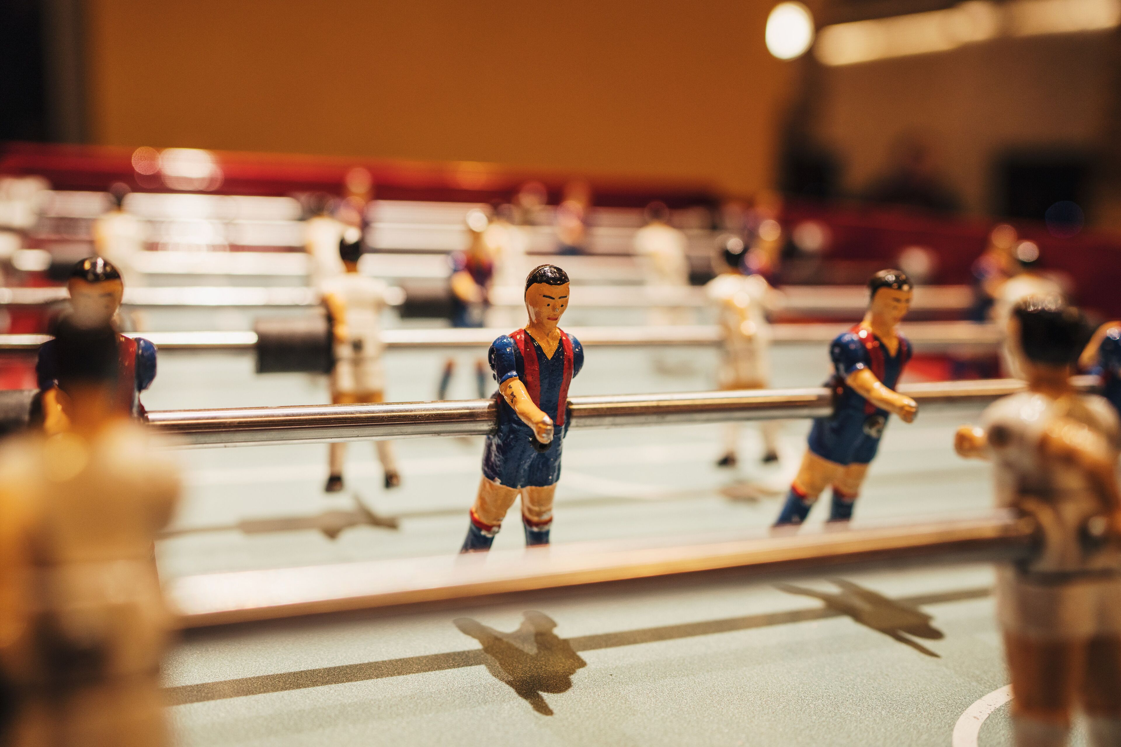 Primer plano de un pequeño partido de fútbol con figuras en una mesa.