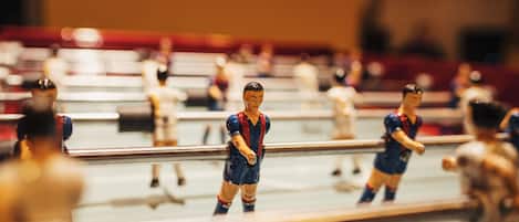Primer plano de un pequeño partido de fútbol con figuras en una mesa.